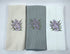 Three kitchen towels with floral embroidery on a white background